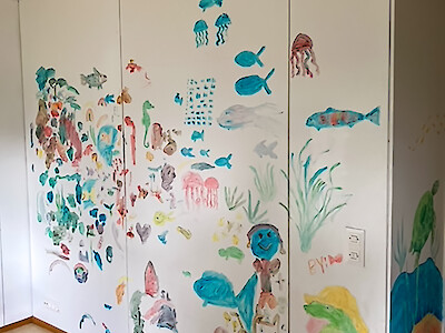 Lasten maalauksia seinällä
